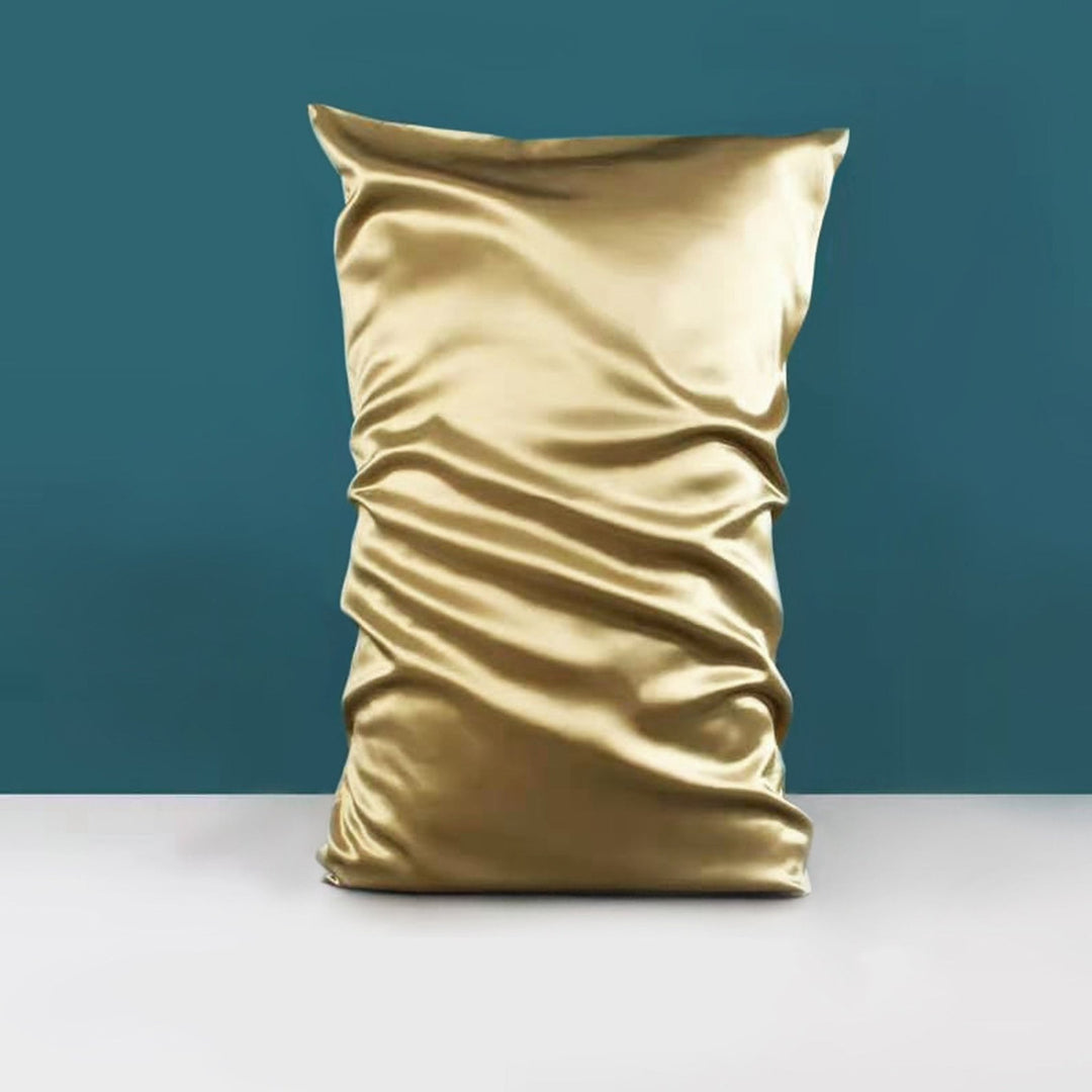 The 22 Momme High Gloss Silk Pillowcase Envelope by SusanSilk, with its golden sheen and expertly crafted folds, is displayed against a teal backdrop, highlighting the luxurious allure of silk.