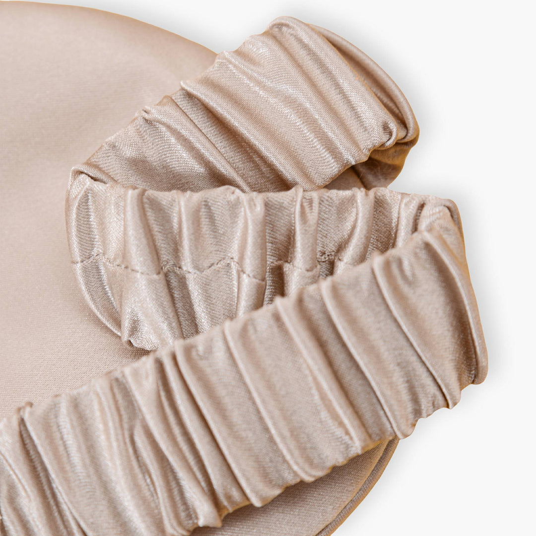Close-up of the Elegant Silk Eye Mask - Golden Pyramid by SusanSilk, resting on a matching-colored silk fabric.