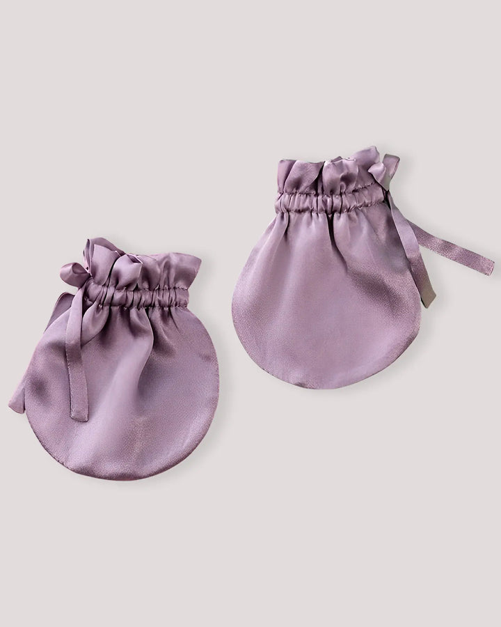 The SusanSilk 19 Momme Baby Silk Gloves Anti-Face Grabbing pouch lies flat against a plain background, showcasing the gathered opening and two drawstrings tied elegantly on one side.