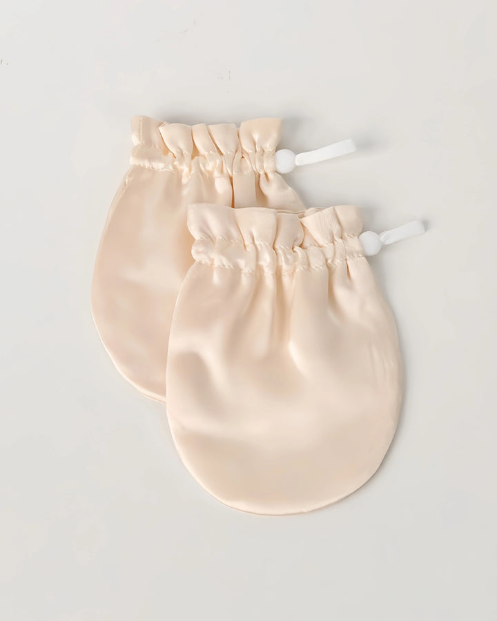 Close-up of ivory 19 momme baby silk gloves highlighting smooth mulberry silk texture that protects baby skin from irritation and scratching.