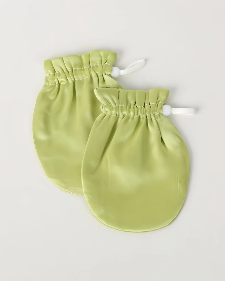 A pair of green 19 momme baby silk gloves with adjustable drawstring cuffs, helping prevent face grabbing while staying breathable and gentle.