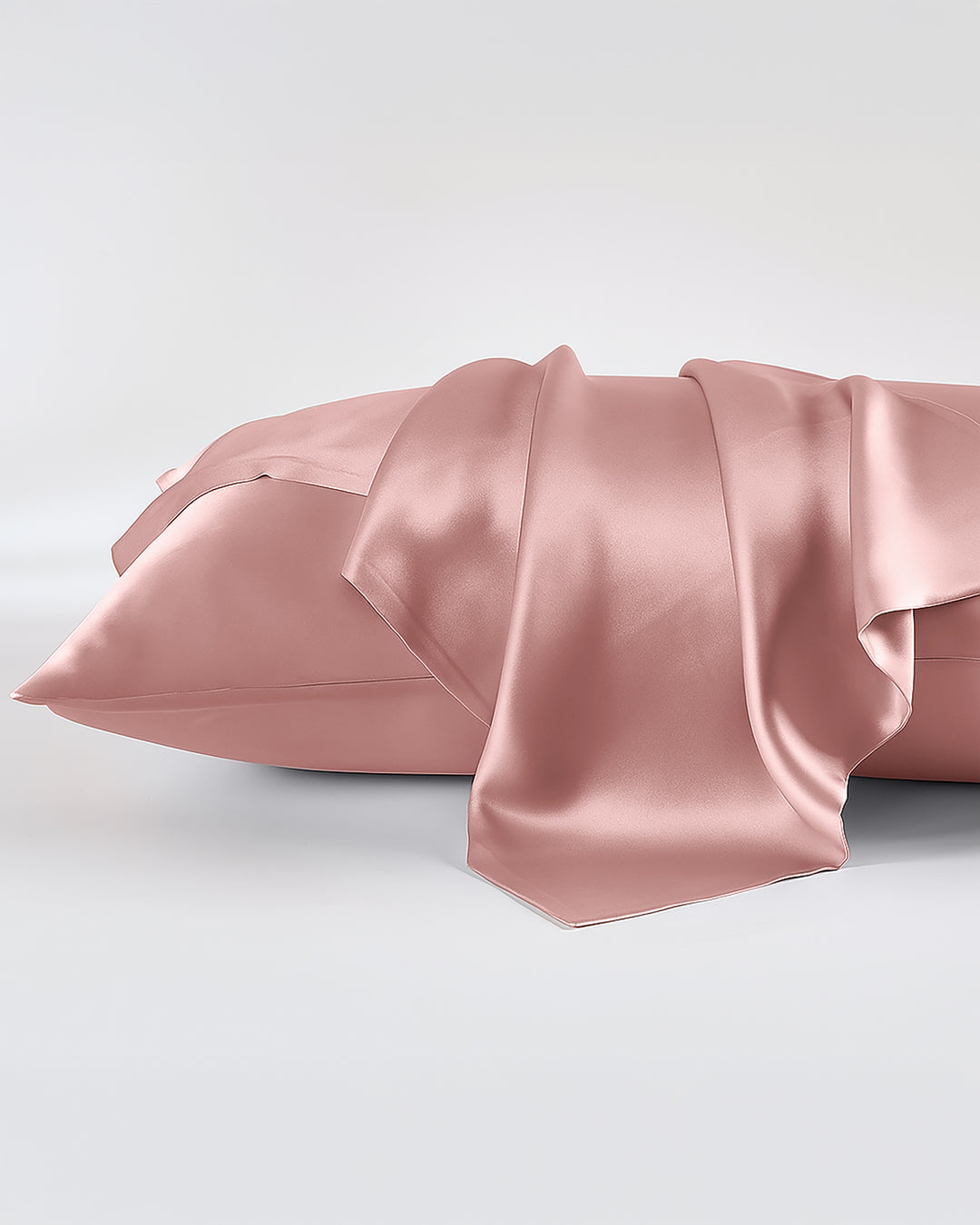 Pink satin pillowcase on a light gray background