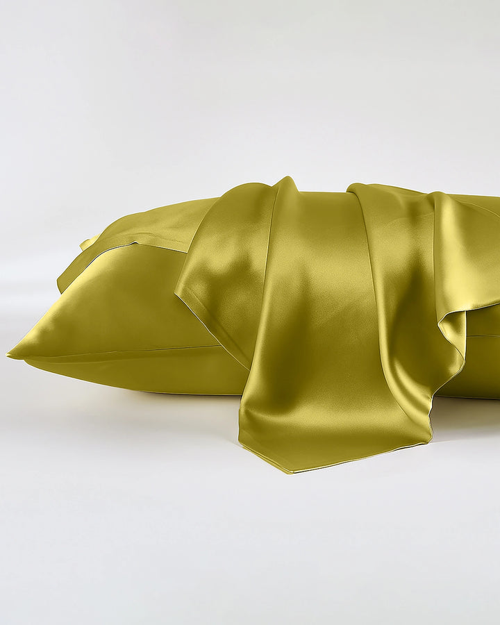 Green satin pillowcases on a white background