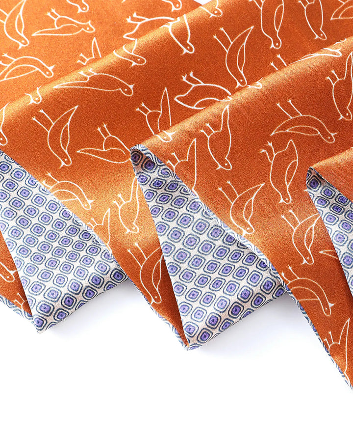 Fabric with white deer pattern on orange background and blue geometric pattern on border