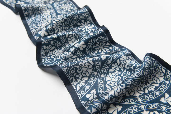 The SusanSilk Blue And White Silk Long Fluttering Belt lies elegantly on a flat surface.