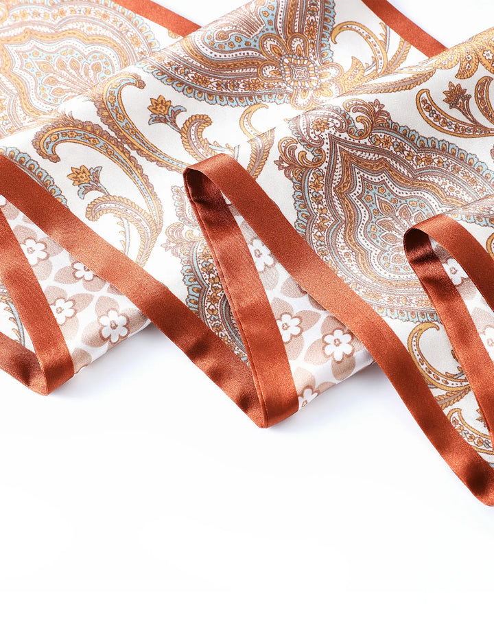 Decorative fabric with paisley pattern and orange satin ribbon on a white background