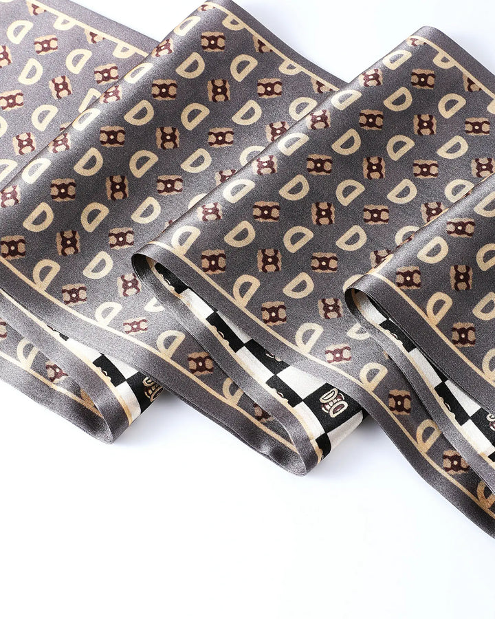 Folded gray necktie with brown and beige pattern on a white background