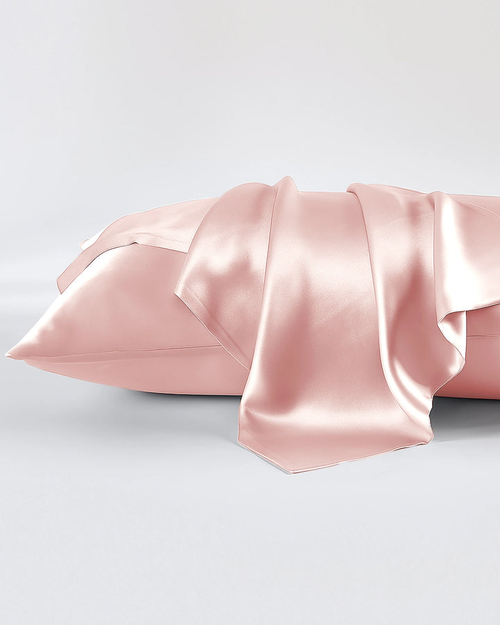 Pink satin pillowcase on a light gray background