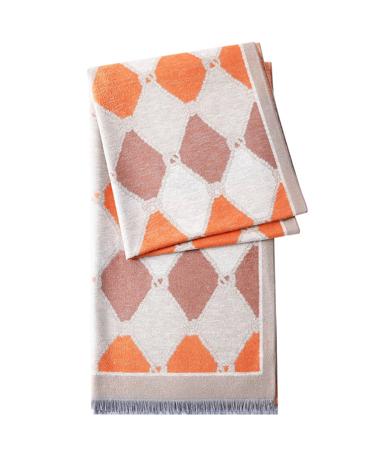 Geometric patterned blanket with orange and pink diamonds on a white background