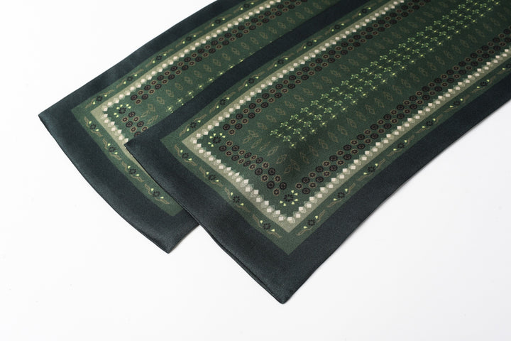 A close-up of the Dark Green Daisy Silk Long Fluttering Belt by SusanSilk, showcasing its intricate geometric design, laid flat on a white background.