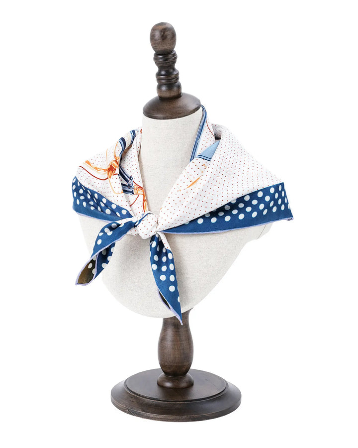 Mannequin head with a white shirt and blue polka dot scarf on a white background