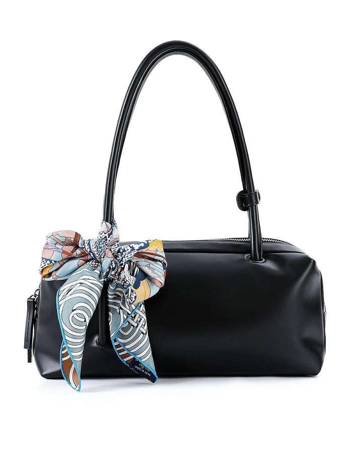 Black handbag with a colorful scarf tied around the handle on a white background