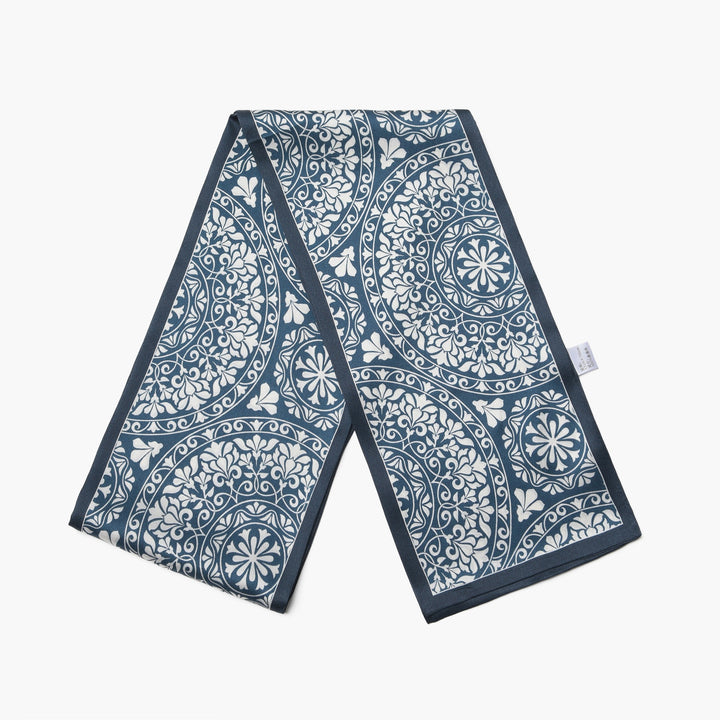 The SusanSilk Blue And White Silk Long Fluttering Belt, made from luxurious silk and featuring an intricate floral pattern, is laid flat against a plain white background.