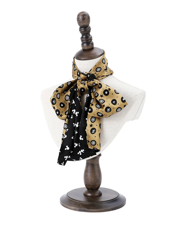 Mannequin with a black and gold patterned scarf on a white background