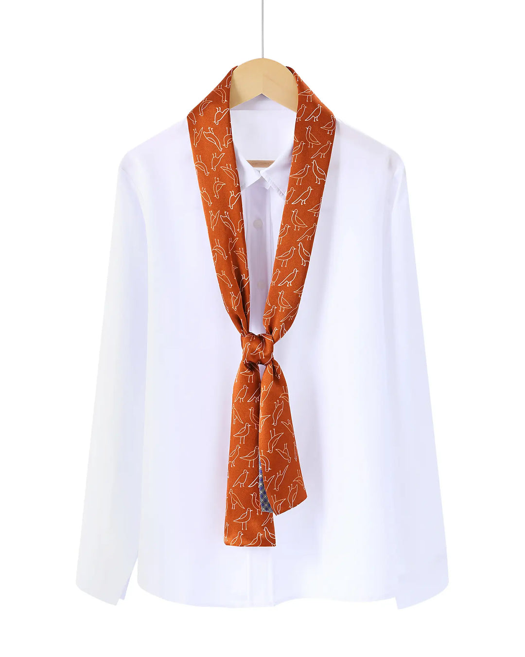 White shirt with an orange patterned scarf tied around the neck on a white background