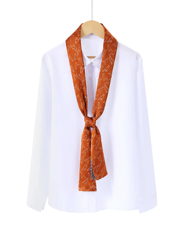 White shirt with an orange patterned scarf tied around the neck on a white background