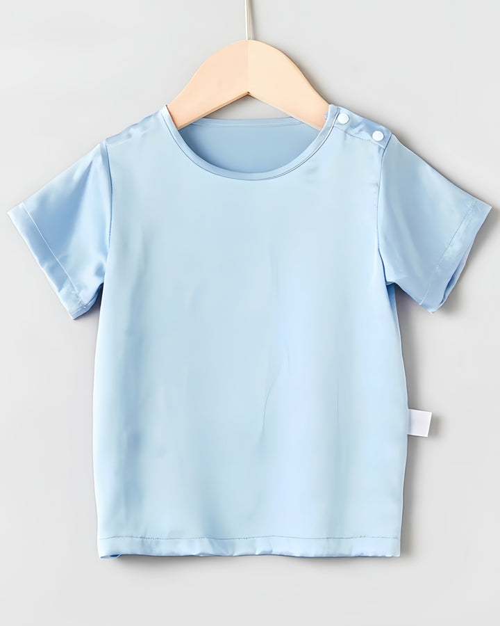 The Sky Blue 19 Momme Baby & Toddler Silk Short Sleeve Top by SusanSilk, featuring a round neckline and side button, hangs on a wooden hanger against a light background—feeling just like baby's second skin.