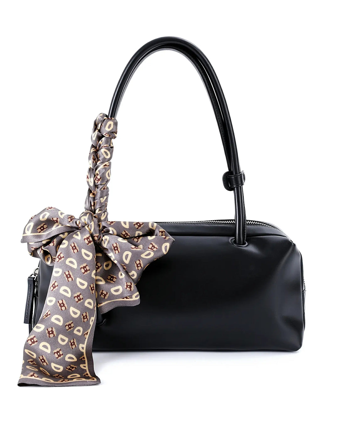 Black handbag with a patterned scarf tied around the handle on a white background
