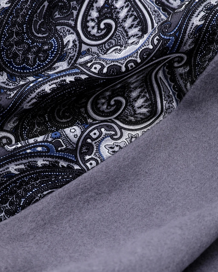 A close-up of a folded fabric item showing a black, white, and blue paisley pattern on one side and a smooth gray suede or faux-suede texture on the other.#color_silver