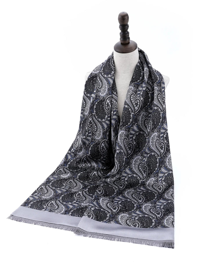 A long scarf with a black and gray paisley pattern and a light gray border, draped on a white mannequin torso against a white background.#color_silver