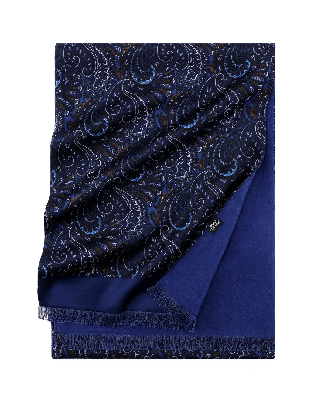 A folded navy blue scarf with a detailed paisley pattern in lighter blue, white, and subtle gold accents, featuring a solid royal blue reverse side and fringed edges.#color_navy-blue