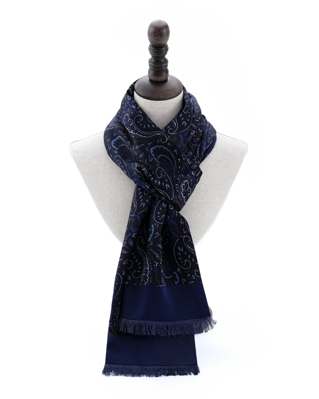 A navy blue scarf with a white paisley pattern, draped on a white mannequin torso with a dark wooden neck cap against a white background.#color_navy-blue