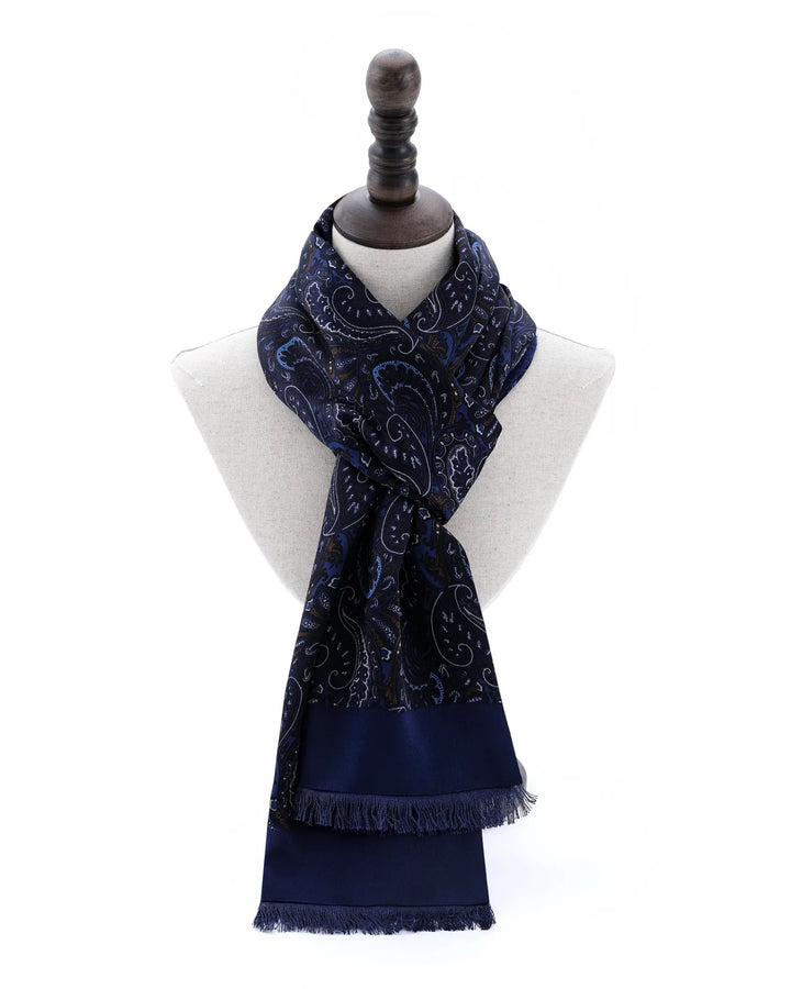 A navy blue scarf with a white paisley pattern, draped on a white mannequin torso with a dark wooden neck cap against a white background.#color_navy-blue