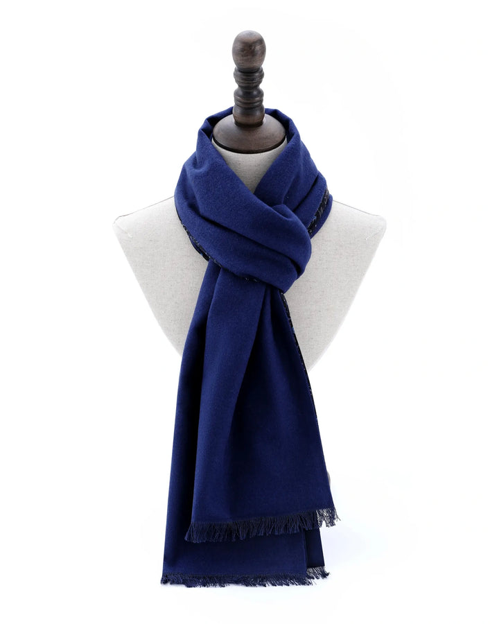 A navy blue scarf with fringed edges, styled on a white dress form mannequin against a plain white background.#color_navy-blue