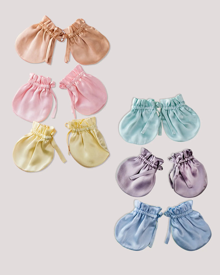 Six pairs of 19 Momme mulberry silk baby scratch mittens displayed by color, featuring a soft elastic cuff and ribbon closure for a gentle, secure fit.
