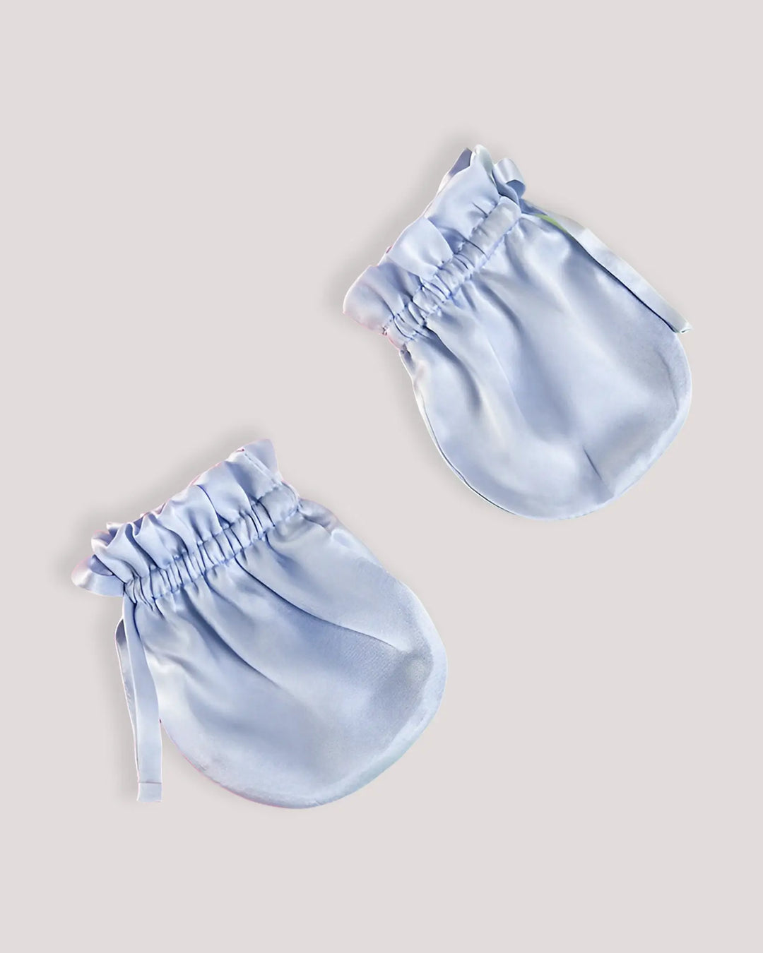 Pair of light blue mulberry silk baby scratch mittens with a secure elastic cuff and ribbon tie to help prevent face scratching and hand chewing.
