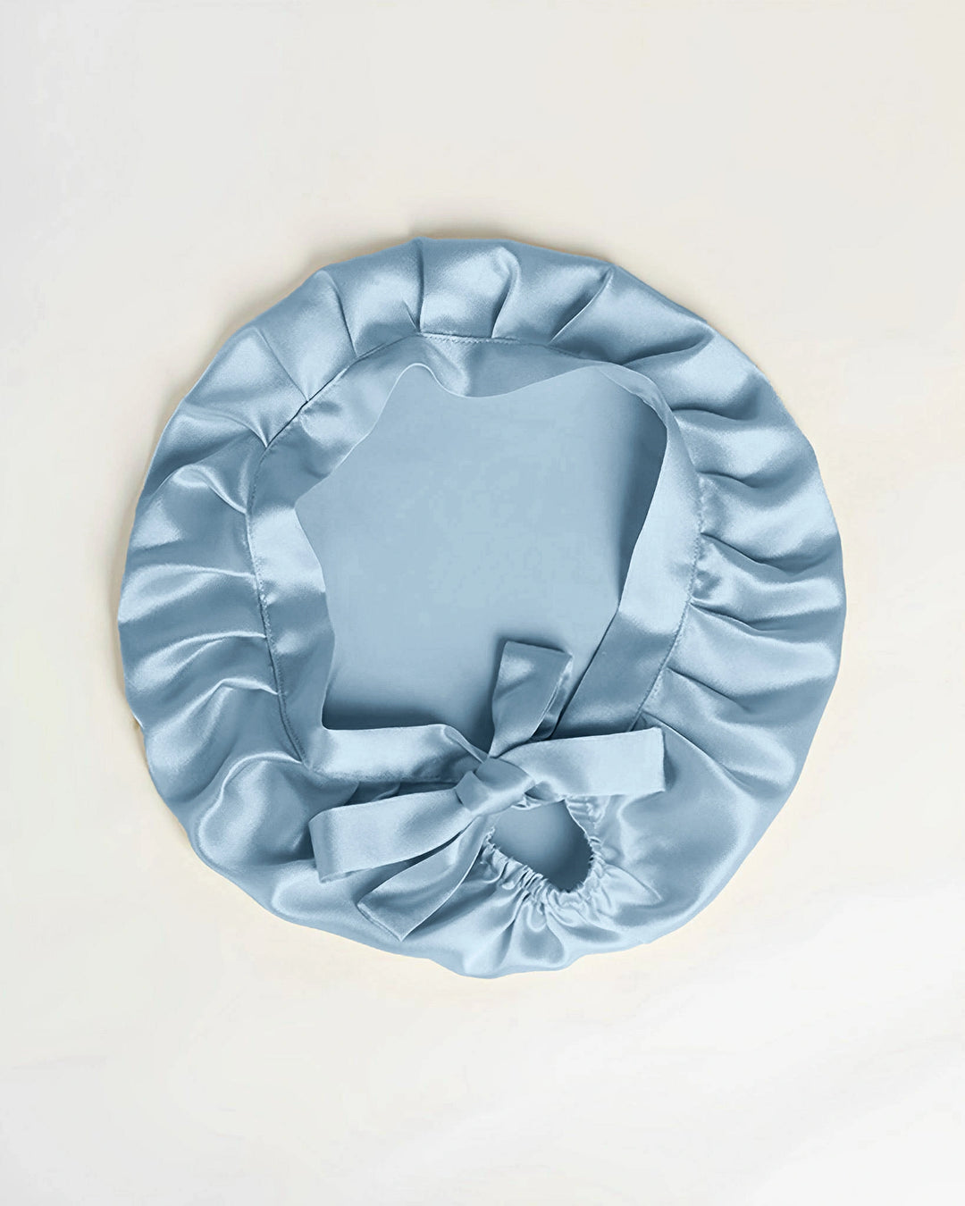 blue mulberry silk tie back sleep bonnet laid flat, elegant silk bonnet with ribbon tie back design