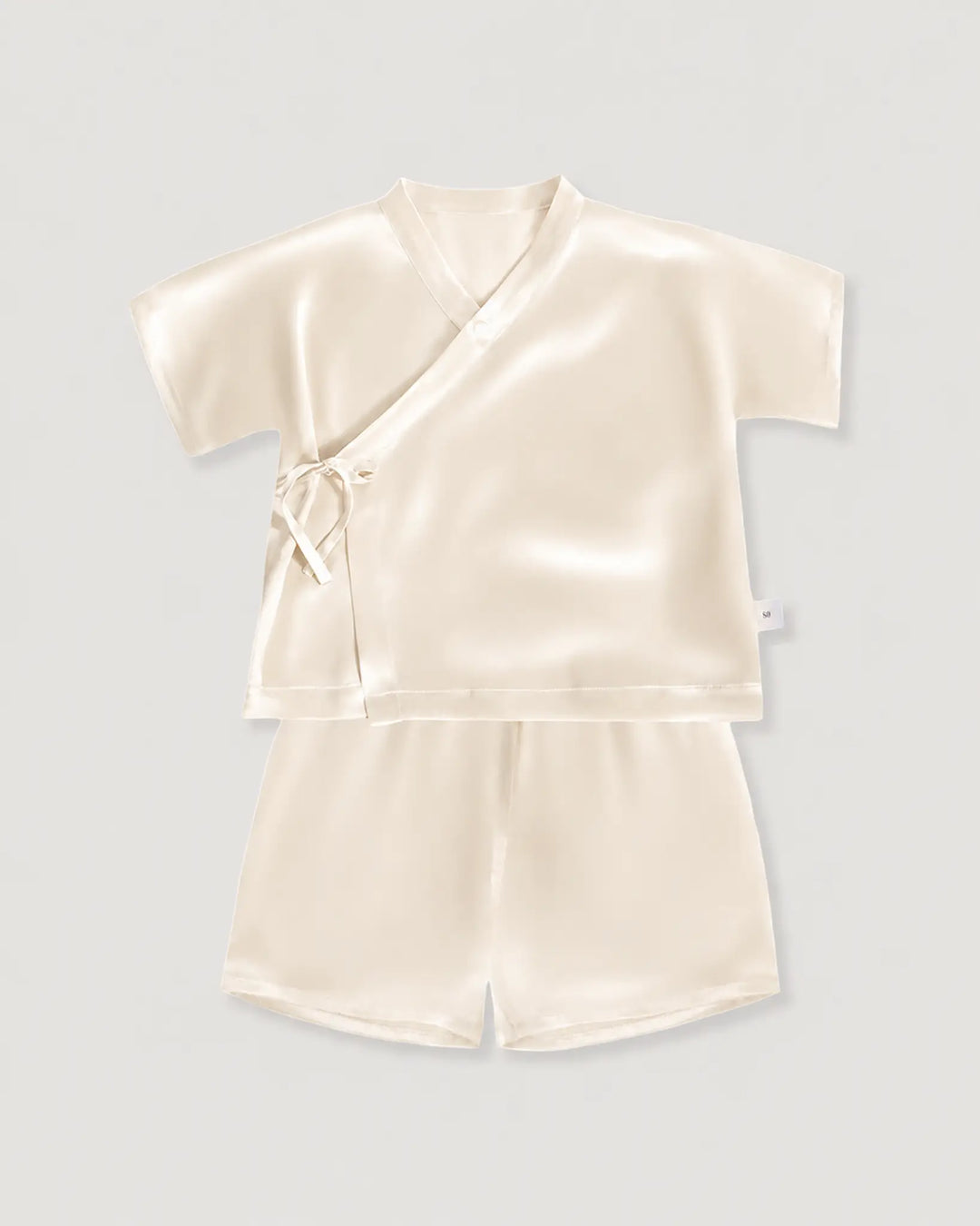 Cream-colored satin top and shorts set on a light gray background