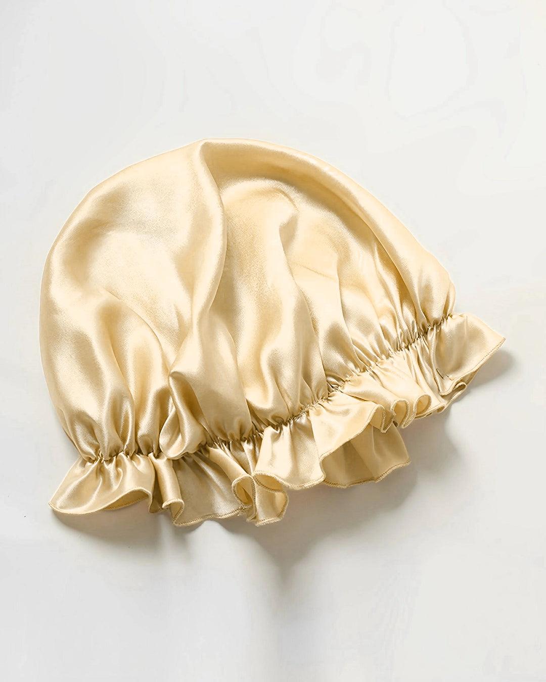 Champagne gold mulberry silk ruffled sleep bonnet laid flat, luxury double layer silk bonnet with soft sheen finish