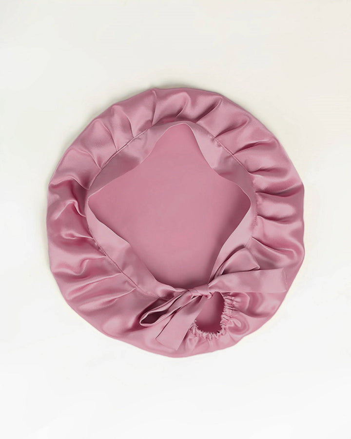 Dusty rose mulberry silk tie back sleep bonnet laid flat, soft double layer silk bonnet with adjustable ribbon