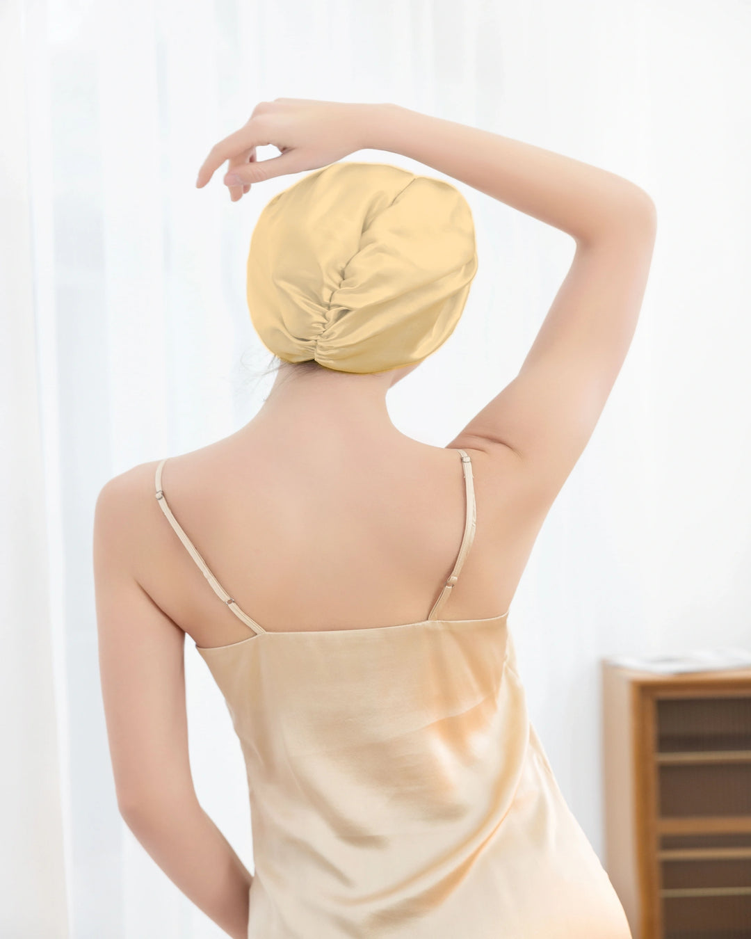 Model wearing mulberry silk sleep bonnet showing elegant wrapped design, soft double layer silk for overnight hair protection