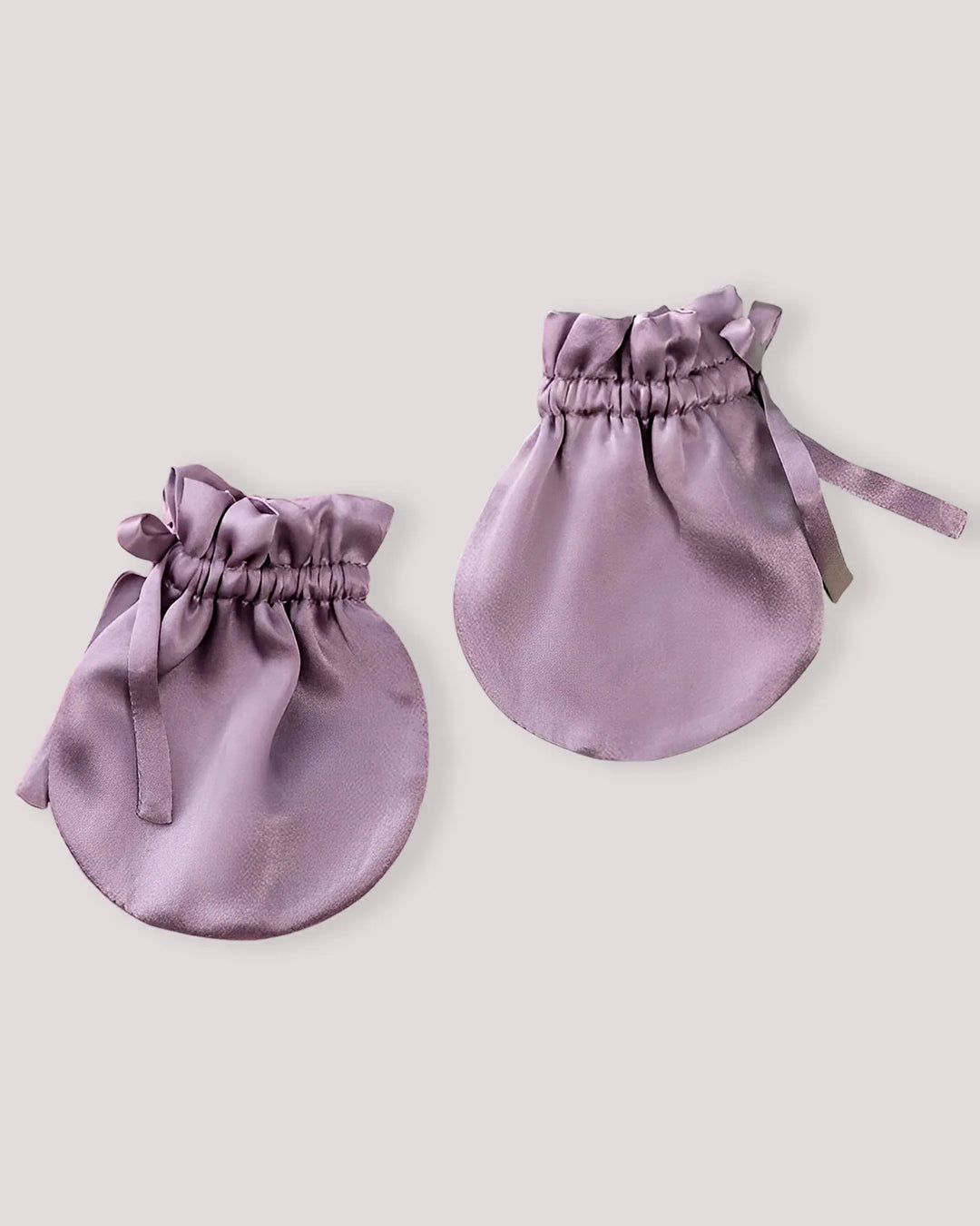 Pair of lavender mulberry silk baby scratch mittens featuring a soft elastic cuff and gentle silk fabric to help protect newborn skin from accidental scratches.