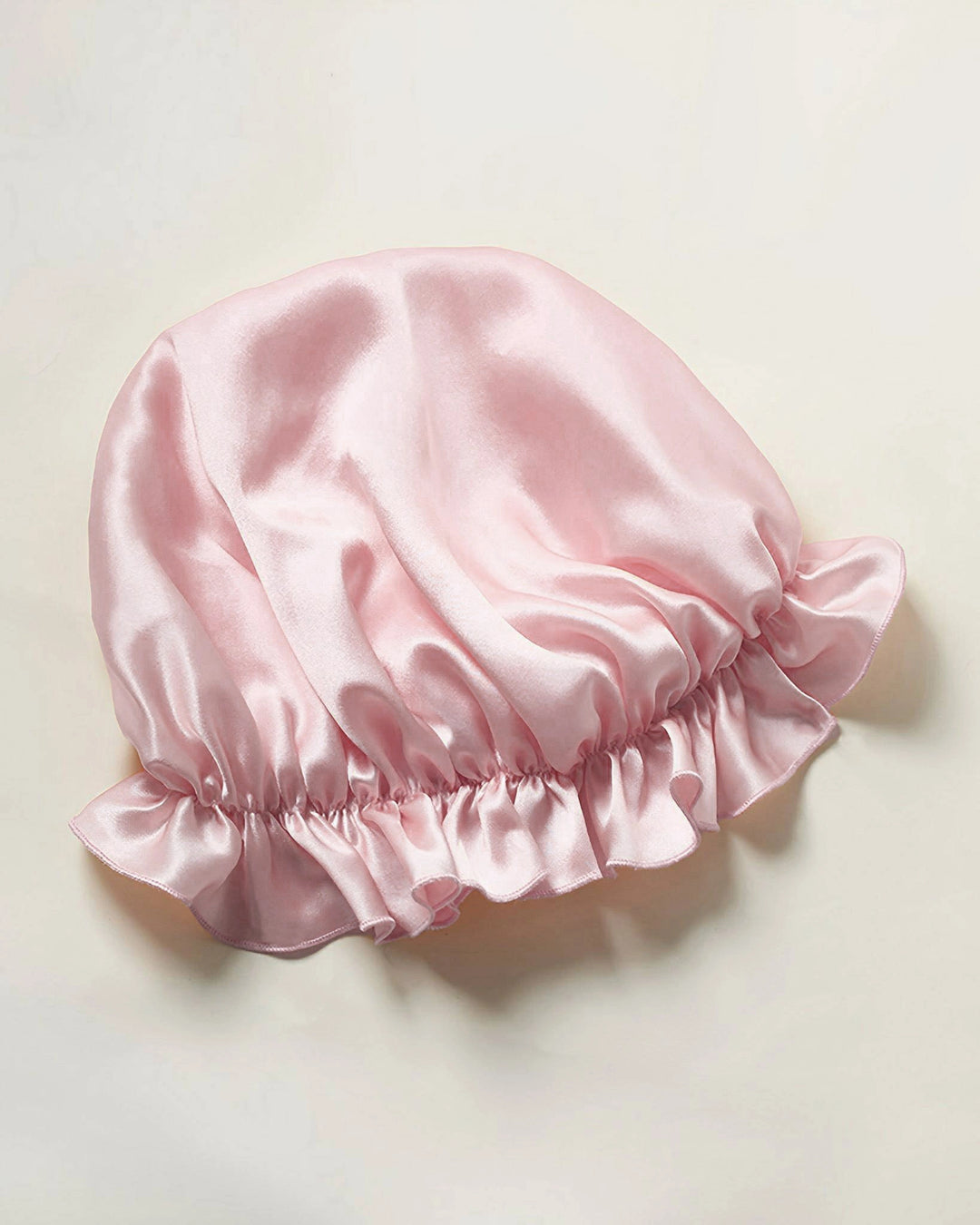 Light pink mulberry silk ruffled sleep bonnet laid flat, breathable smooth silk bonnet suitable for all hair types