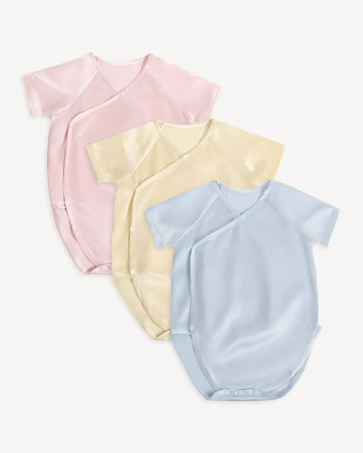 Three 19 momme mulberry silk baby kimono bodysuits in blush pink butter cream and ice blue colors