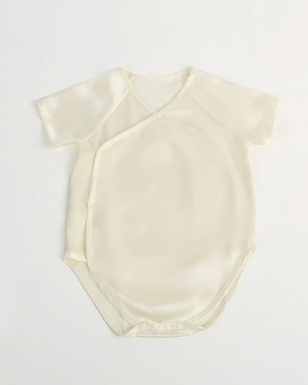 Cream-colored baby bodysuit on a light gray background