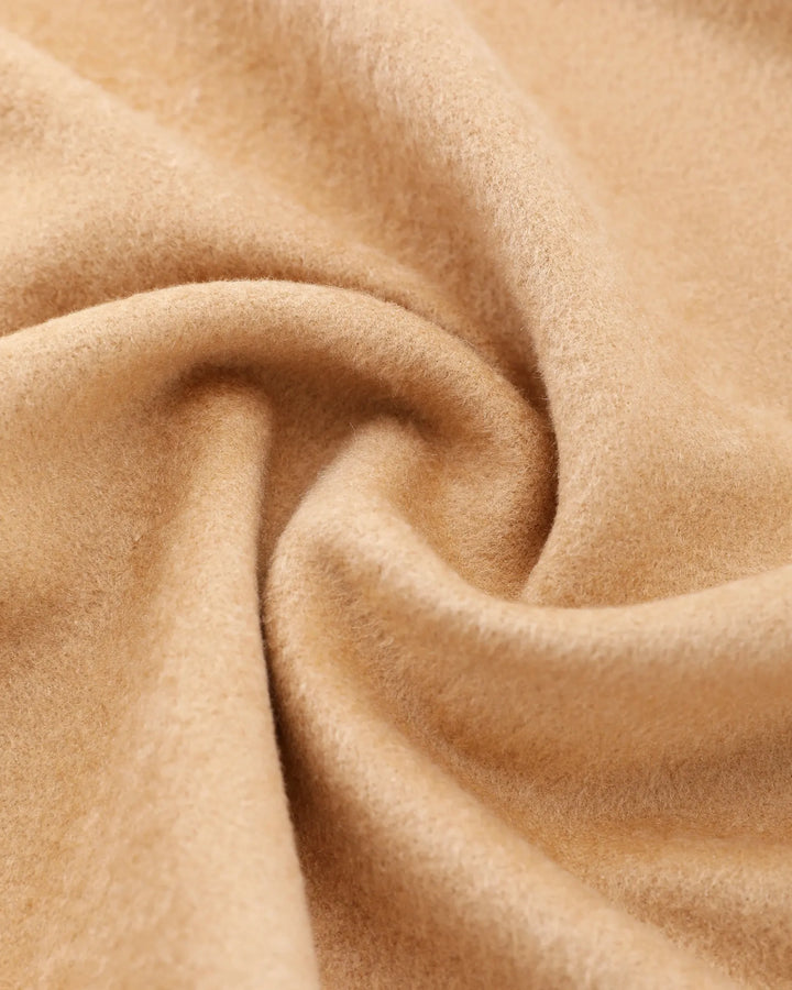 Close-up of soft brushed mulberry silk fabric with warm texture and luxurious feel.#color_forest-green