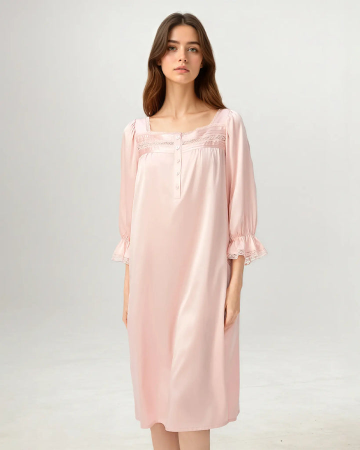 Woman seated wearing soft pink mulberry silk nightgown designed for sleep and lounging.#color_rose-pink