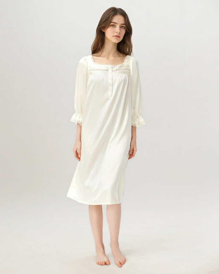 Woman standing wearing ivory white mulberry silk nightgown with french-inspired silhouette.#color_creamy-white