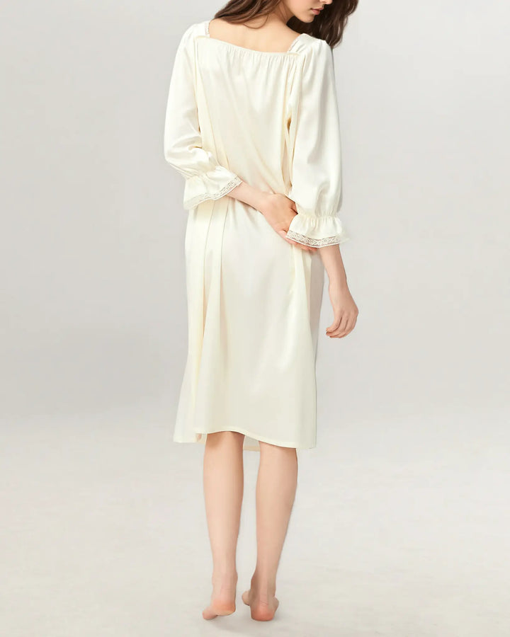 Side view of women’s ivory white silk nightdress showing airy drape and midi length.#color_creamy-white