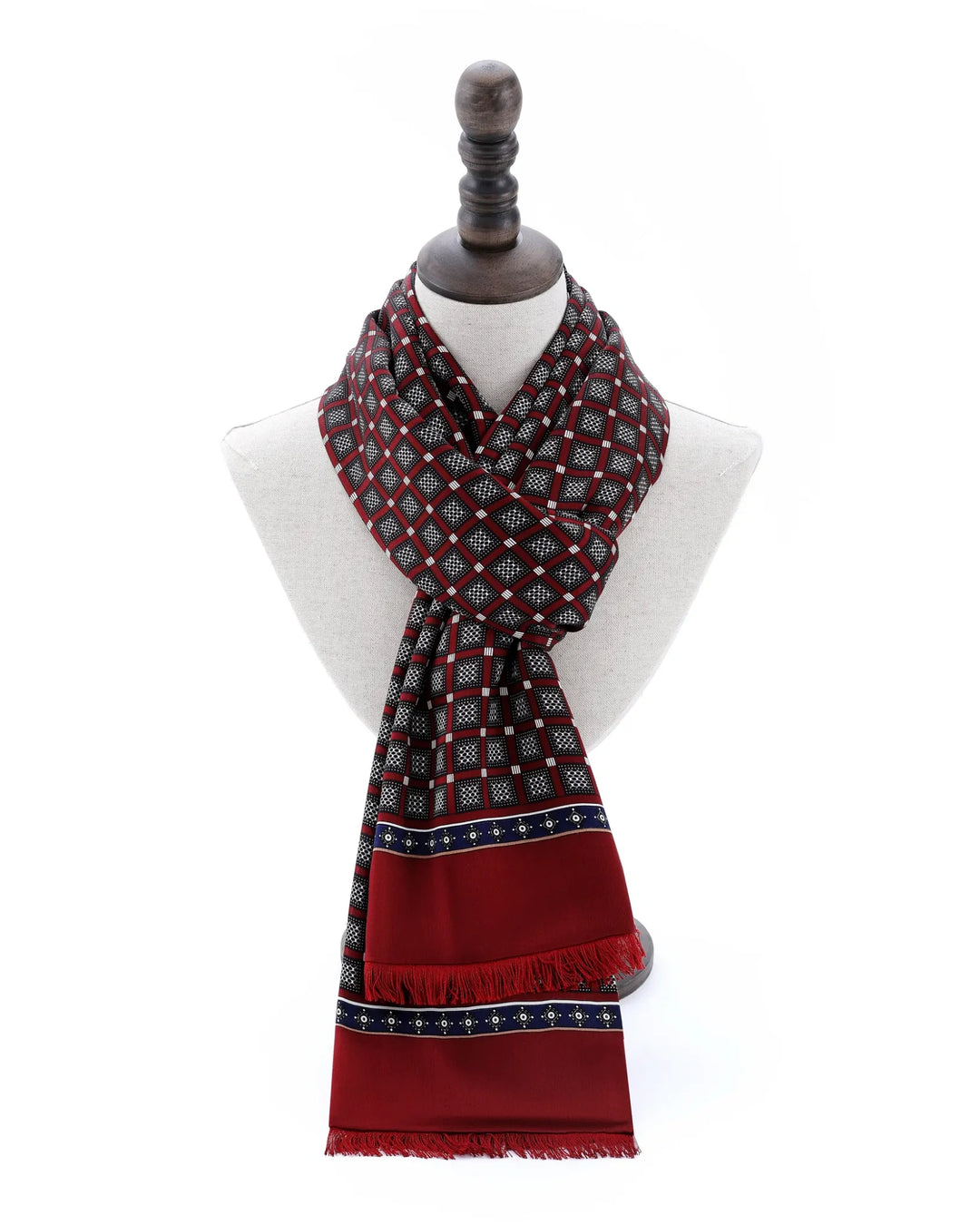 A patterned scarf in deep red, black, and white, styled on a white mannequin bust with a dark wooden neck cap against a plain white background.#color_wine-red