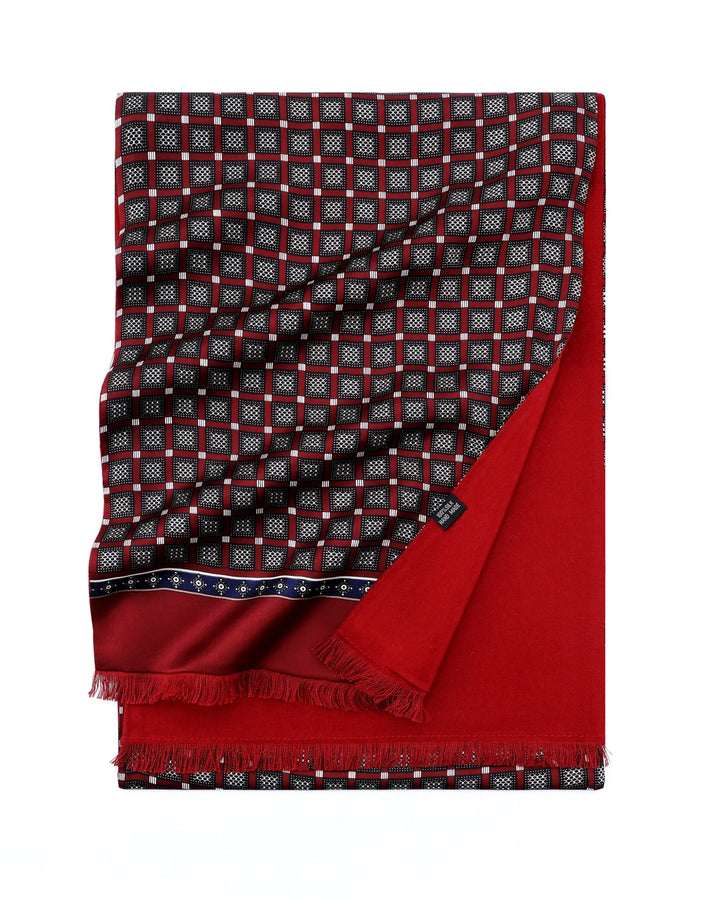 A folded red and black patterned scarf with white geometric details, featuring a solid red reverse side and fringed edges, shown on a plain white background.#color_wine-red