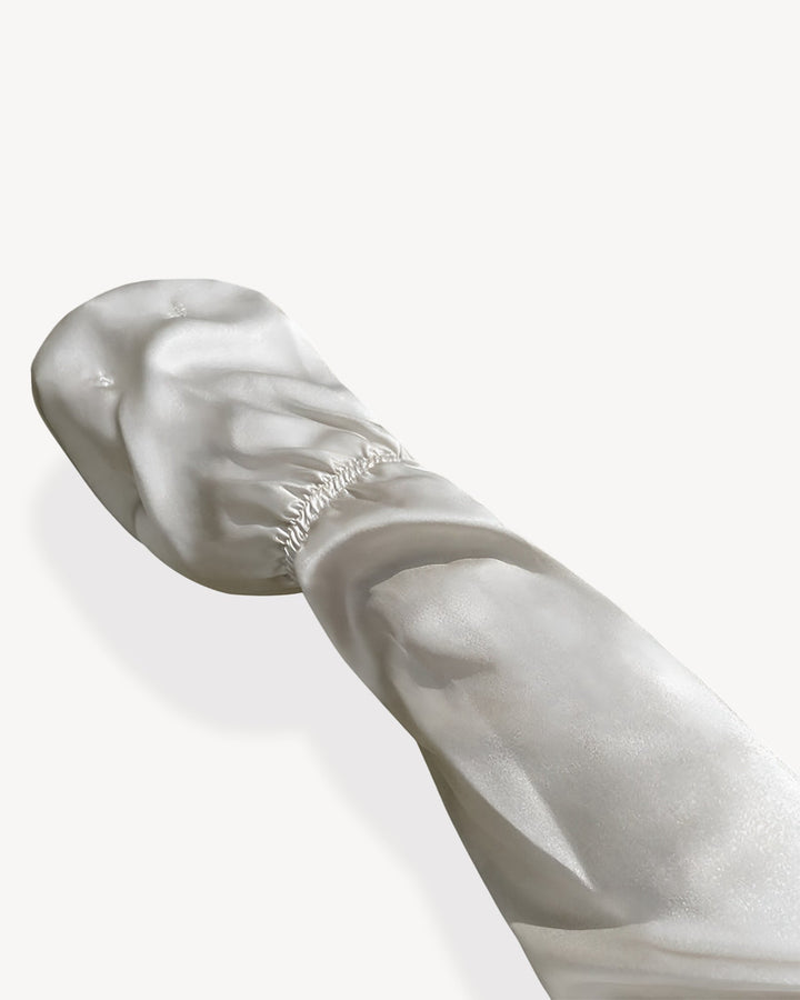 A pair of white Sun Protection Silk Over Sleeves with elastic bands, crafted from luxurious SusanSilk material, is displayed against a plain background.