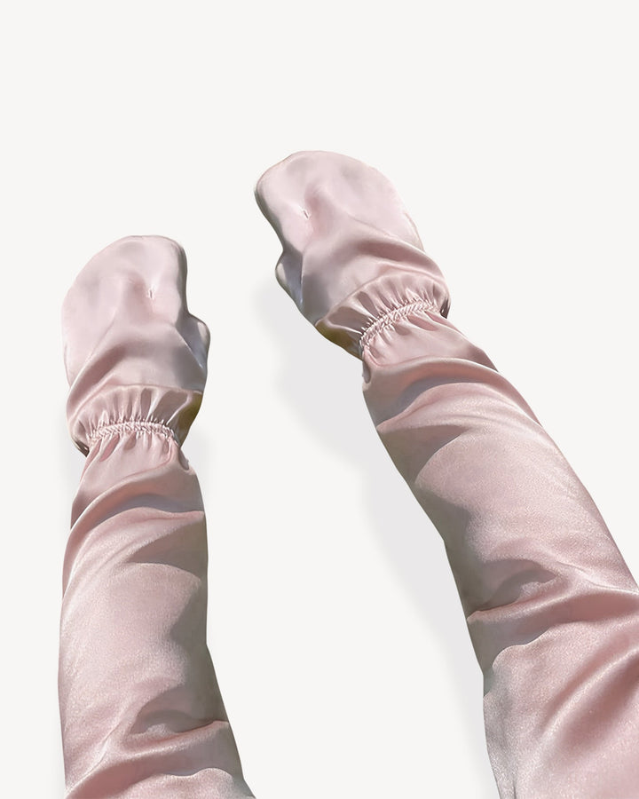 Two pink Sun Protection Silk Over Sleeves by SusanSilk, featuring elasticated wrists, are laid flat on a white surface.