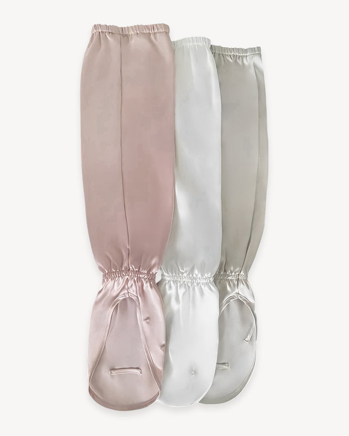 Three Sun Protection Silk Over Sleeves from SusanSilk in pink, white, and light grey are displayed side by side against a plain background, showcasing the luxurious feel of the brand.
