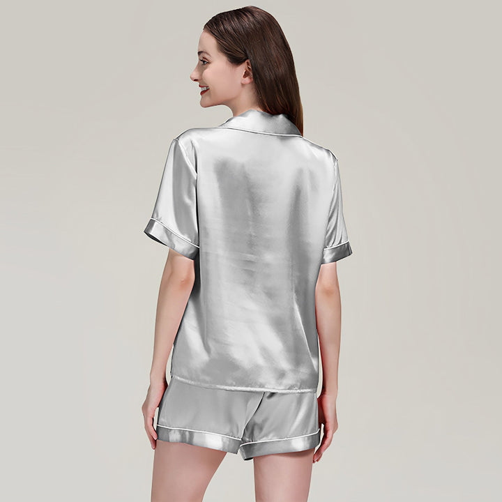 A person with long hair is wearing the 19 Momme Short Silk Pajamas Set from SusanSilk and is standing with their back facing the camera.
