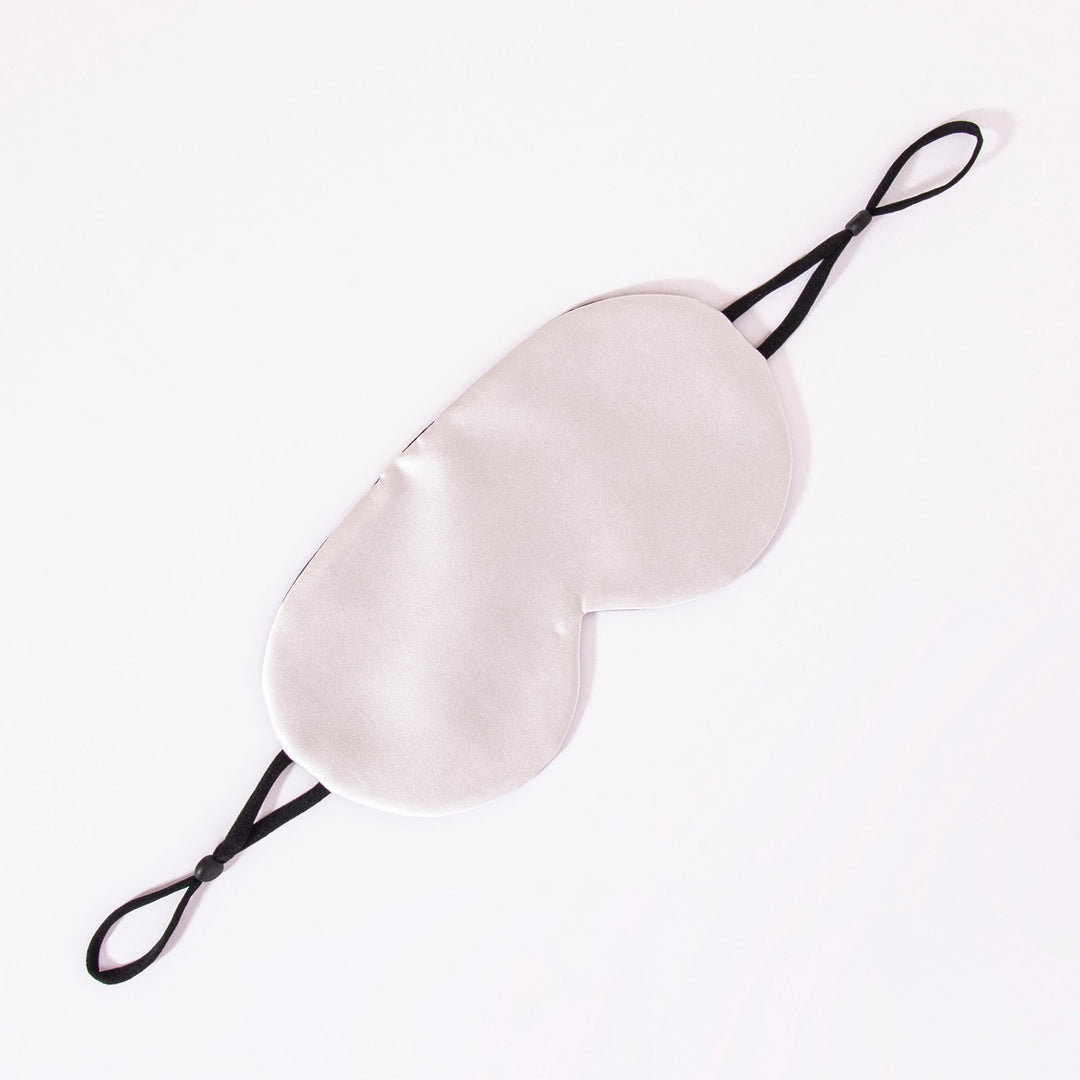 An Earth Tones Double Side Silk Eye Mask by SusanSilk, featuring black elastic straps, is laid flat on a white background.